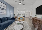 Thumbnail 35 of 41 - A modern living room with a dark blue sofa and a wooden cabinet.