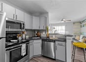 Thumbnail 2 of 22 - an open kitchen with stainless steel appliances and white cabinets