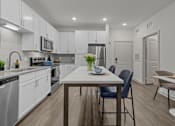 Thumbnail 36 of 41 - A modern kitchen with a dining table and chairs.