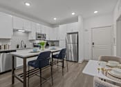 Thumbnail 38 of 41 - A modern kitchen with a dining table and chairs.
