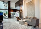 Thumbnail 11 of 26 - A modern living room with a grey sofa and a patterned wallpaper.