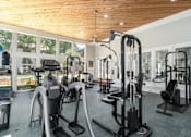 Thumbnail 15 of 19 - A gym with a variety of equipment including treadmills, stationary bikes, and weight machines.