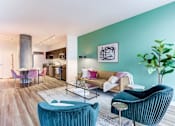 Thumbnail 1 of 19 - A living room with a blue chair and a green plant.