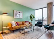 Thumbnail 2 of 19 - A living room with a green wall and a large window.
