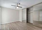 Thumbnail 8 of 19 - A room with a ceiling fan and sliding glass doors.