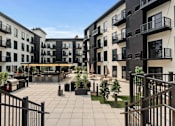 Thumbnail 9 of 35 - A courtyard surrounded by black and white buildings with balconies.