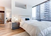 Thumbnail 8 of 19 - A bedroom with a large bed and a view of a building outside the window.