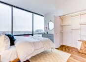 Thumbnail 11 of 19 - A bedroom with a large bed and a window overlooking the city.