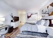 Thumbnail 9 of 19 - A modern bedroom with a large bed and a chair.