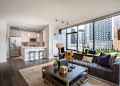 Thumbnail 1 of 26 - A modern living room with a black leather couch and a coffee table in the center.