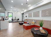 Thumbnail 11 of 25 - A modern office space with a black leather ottoman and a white table with a red book on it.