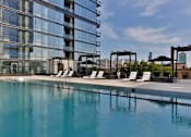 Thumbnail 16 of 19 - A large swimming pool in front of a modern building.