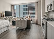 Thumbnail 5 of 26 - A modern living room with a large bed and a kitchen area.