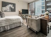 Thumbnail 6 of 26 - A bedroom with a large bed and a couch with a city view.