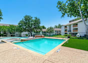 Thumbnail 10 of 19 - A large swimming pool surrounded by a fence and trees.