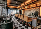 Thumbnail 15 of 26 - A restaurant with black and white checkered flooring and wooden chairs.