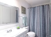 Thumbnail 12 of 27 - a white bathroom with a shower curtain and a sink