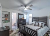 Thumbnail 9 of 27 - a bedroom with a bed and a ceiling fan