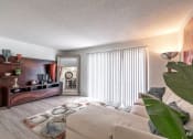 Thumbnail 6 of 27 - a living room with a couch and a tv and a large window
