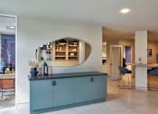 Thumbnail 20 of 27 - A kitchen with a blue cabinet and a counter with a plant on it.