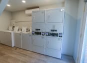 Thumbnail 13 of 21 - a row of white washers and dryers in a room