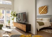 Thumbnail 3 of 16 - A modern bedroom with a large bed and a flat screen TV.