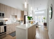 Thumbnail 6 of 16 - A modern kitchen with wooden cabinets and a white island.