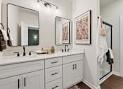 Thumbnail 15 of 16 - A bathroom with two sinks and a large mirror.