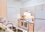 Thumbnail 28 of 29 - a kitchen with white appliances and wooden cabinets