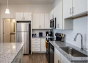 Thumbnail 15 of 45 - a kitchen with white cabinets and a stainless steel refrigerator