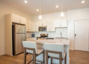 Thumbnail 17 of 45 - a kitchen with a marble counter top and a stainless steel refrigerator