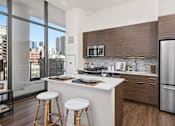 Thumbnail 1 of 25 - A modern kitchen with a view of the city.