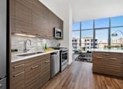 Thumbnail 3 of 25 - A modern kitchen with wooden cabinets and stainless steel appliances.