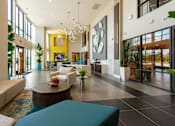 Thumbnail 18 of 25 - a lobby with couches and a table