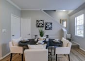 Thumbnail 12 of 34 - A dining room with a black table and white chairs.