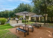 Thumbnail 9 of 29 - a picnic area with benches and umbrellas in a park
