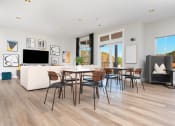 Thumbnail 3 of 33 - a living room with a table and chairs and a couch in the background