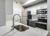 Thumbnail 25 of 29 - a kitchen with white cabinets and stainless steel appliances