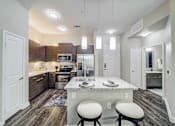 Thumbnail 3 of 26 - A kitchen with a white island and bar stools.