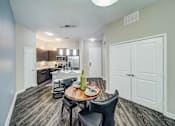 Thumbnail 6 of 26 - A modern kitchen with a dining table set for two.