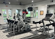 Thumbnail 17 of 29 - A gym with treadmills, elliptical machines, and other cardio equipment.