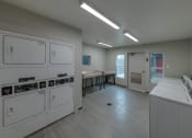 Thumbnail 15 of 19 - a laundry room in a building with washes and dryers