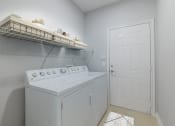 Thumbnail 26 of 39 - a white washer and dryer in a laundry room with a white door