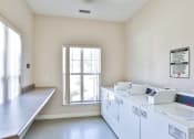 Thumbnail 8 of 29 - an empty laundry room with washers and dryers and a window