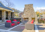 Thumbnail 2 of 25 - a patio with couches and a fireplace in front of a house