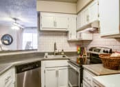 Thumbnail 14 of 25 - a kitchen with white cabinets and appliances and a sink