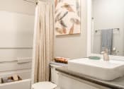 Thumbnail 20 of 25 - a bathroom with a sink and a shower with a shower curtain