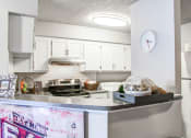Thumbnail 15 of 25 - a kitchen with white cabinets and a counter top and a refrigerator