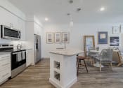Thumbnail 7 of 43 - a kitchen and living room with a table and chairs