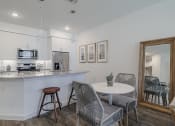 Thumbnail 5 of 43 - a small dining area next to a kitchen with a breakfast bar